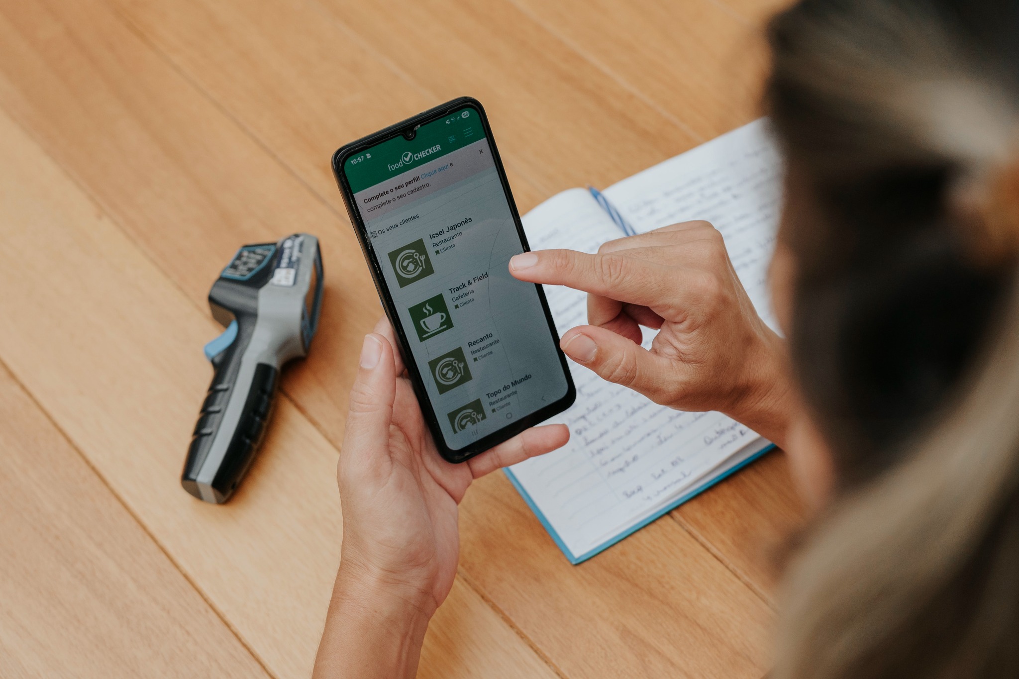 Profissional consultando informações no celular durante uma atividade de segurança de alimentos